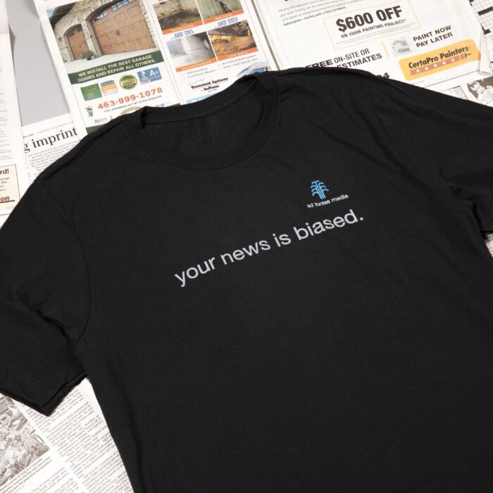 your news is biased shirt on top of newspapers